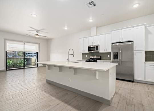 A modern kitchen with white cabinets and a large island.