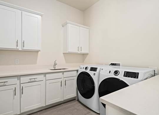 A white laundry room with a washer and dryer.