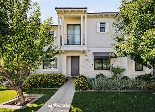 A two-story house with a balcony on the second floor.