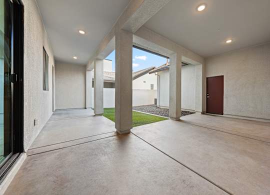 A long hallway with a door on the right and a window on the left.