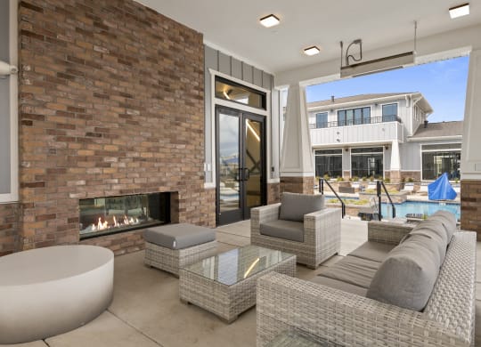 lounge area with fireplace outside by pool