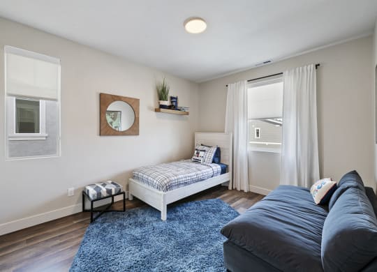 Furnished bedroom with wood plank flooring