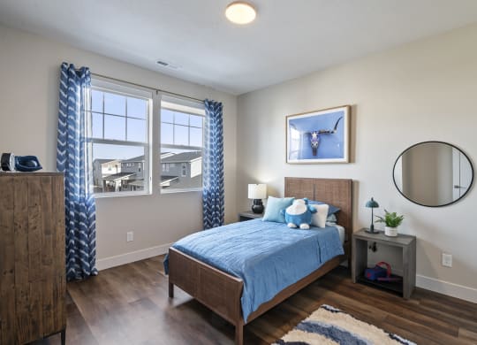 Furnished bedroom with wood plank flooring