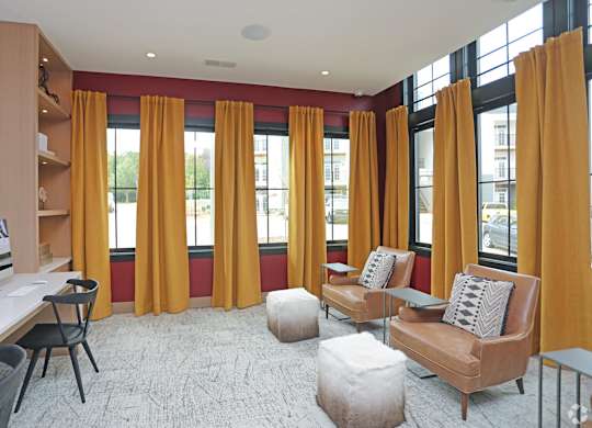 A living room with a brown couch, a white desk, and a chair.at 198 Milltown Apartments, Burlington, NC  