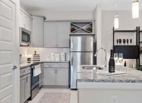 A kitchen with a refrigerator, microwave, and sink.at 198 Milltown Apartments, Burlington  