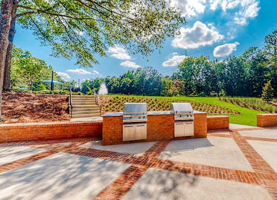 a patio with a barbecue grill and a view of a garden at Inverness Cliffs, Birmingham