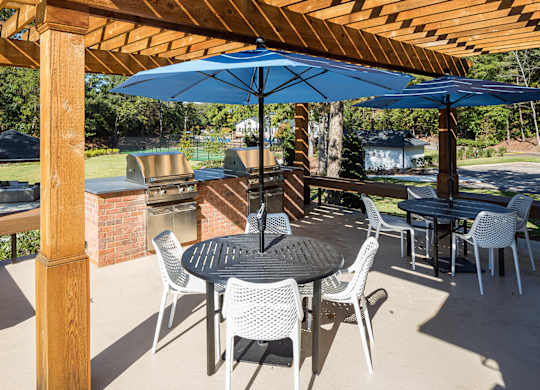 a patio with tables and chairs and umbrellas at Inverness Cliffs, Birmingham, AL