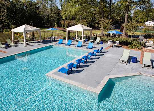 a swimming pool with blue lounge chairs and umbrellas at Inverness Cliffs, Birmingham