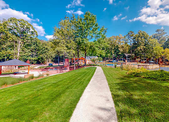 a path leading to a park with a playground and a lake at Inverness Cliffs, Birmingham, 35242