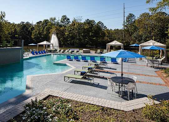 a swimming pool with lounge chairs and umbrellas at Inverness Cliffs, Birmingham, 35242