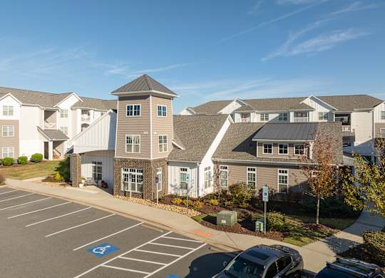 A parking lot with a car and a handicap sign. at Concord Ridge Apartments, Concord, North Carolina