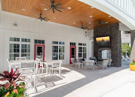 A patio with a white table and chairs and a ceiling fan. at Concord Ridge Apartments, Concord, North Carolina