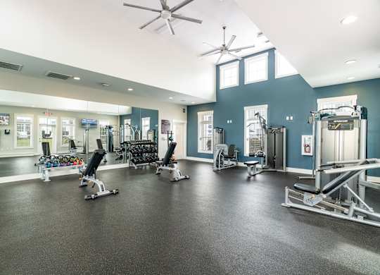 A gym with a variety of equipment including weights and cardio machines. at Concord Ridge Apartments, Concord