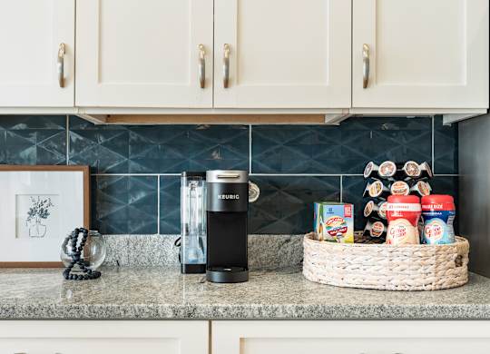 A kitchen counter with a basket of food and a coffee maker. at Concord Ridge Apartments, North Carolina, 28027