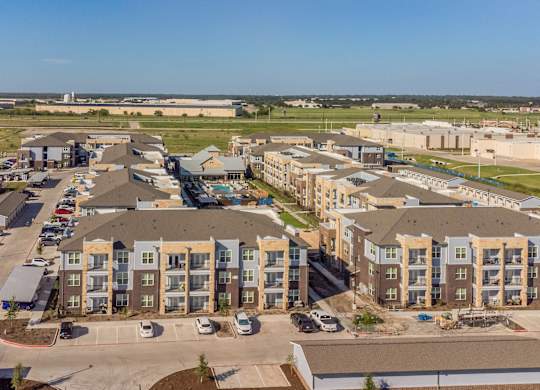 an aerial view of an apartment complex with cars parked in a parking lot at Magnolia Grove Apartments, Terrell, TX
