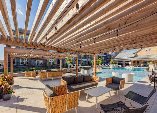 A wooden pergola with a pool in the background. at Magnolia Grove Apartments, Terrell, TX