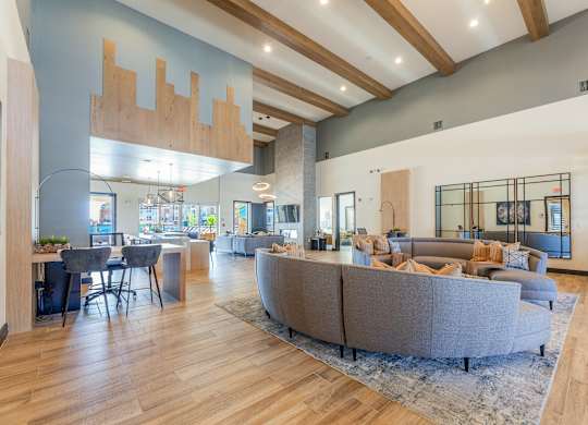 A spacious living room with a grey sofa set and wooden flooring. at Magnolia Grove Apartments, Terrell, Texas