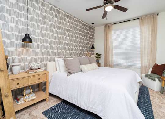 a bedroom with a white bed and a white brick wall at Terraces at Town Center, Jacksonville