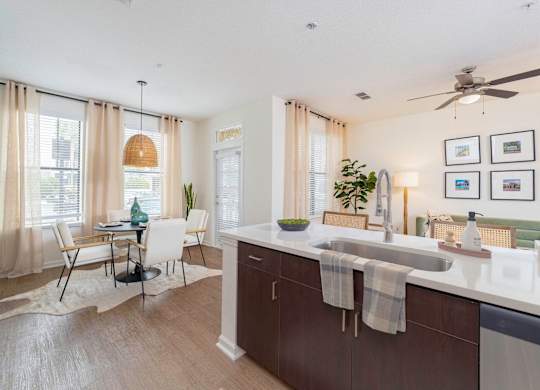 a kitchen and dining room with a sink and a ceiling fan at Terraces at Town Center, Jacksonville