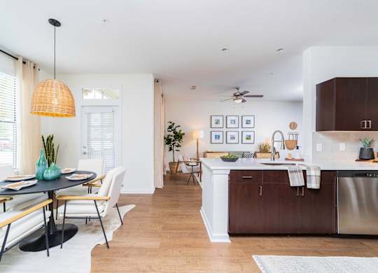 a living room and kitchen with a dining room table and chairs at Terraces at Town Center, Jacksonville