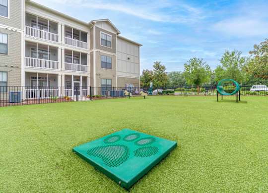 a green yard with a yoga mat in front of an apartment building at Terraces at Town Center, Jacksonville