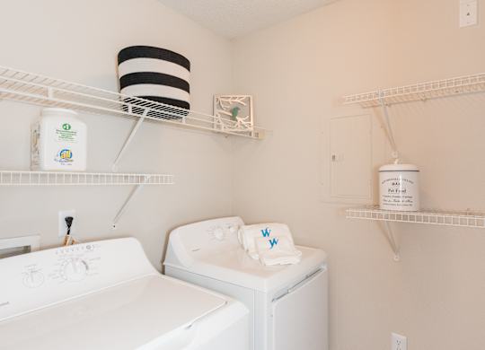 A white washing machine and dryer in a small laundry room. at WildForest Apartments, Alabama, 35209