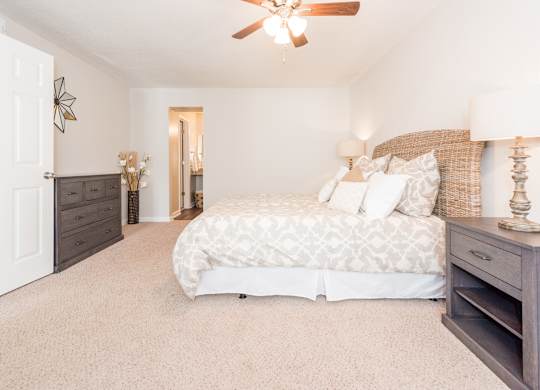 A bedroom with a large bed and a ceiling fan. at WildForest Apartments, Birmingham, Alabama