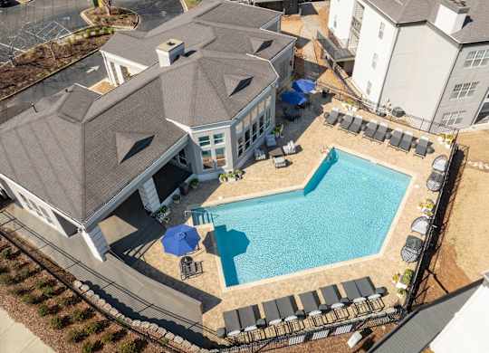 an aerial view of a large swimming pool in front of a house at WildForest Apartments, Birmingham, AL