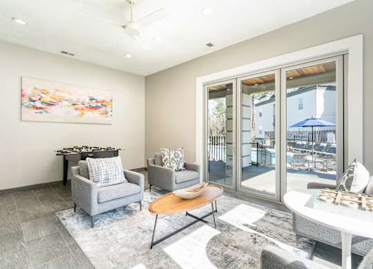 a living room with a table and chairs and sliding glass doors at WildForest Apartments, Birmingham, AL