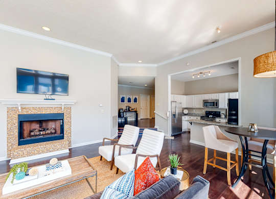 a living room with a fireplace and a kitchen with a table and chairs at WildForest Apartments, Birmingham