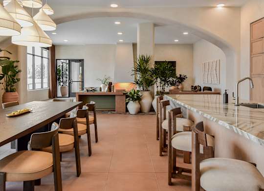 A kitchen with a long table and chairs.
