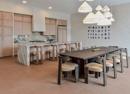 A modern kitchen with a dining table and chairs.