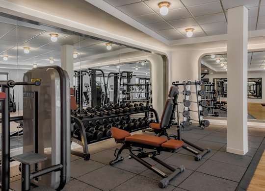 A gym with a variety of equipment including weights and machines.