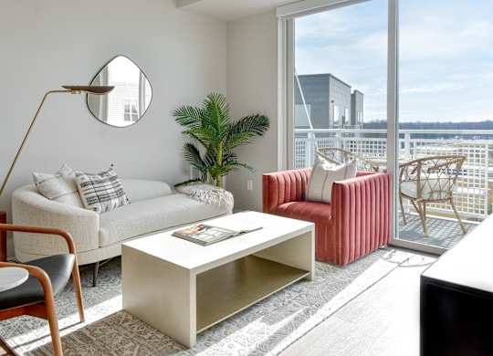 Hopkins, MN Luxury Apartments Near Target - The Hallon - Furnished Living Room with Wood-Finish Plank Flooring, Sliding Glass Door to Private Balcony, and Beautiful Views