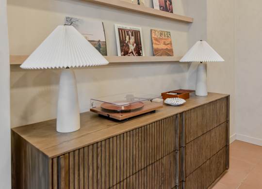 A wooden cabinet with a lamp and a book on top.