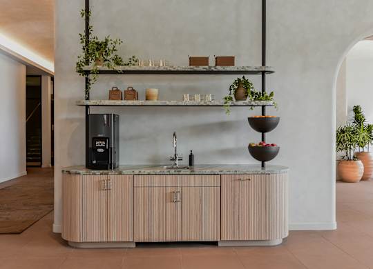 A modern kitchen with a wooden counter and a black fridge.