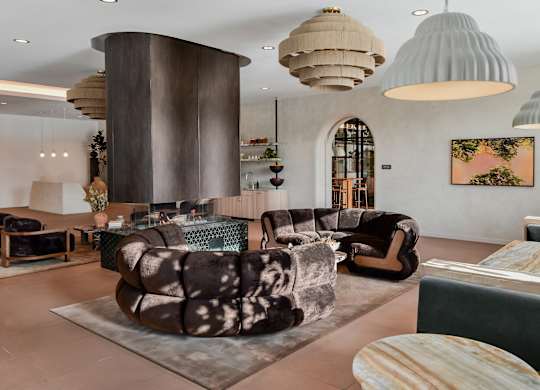 A modern living room with a large circular column and a variety of seating options.