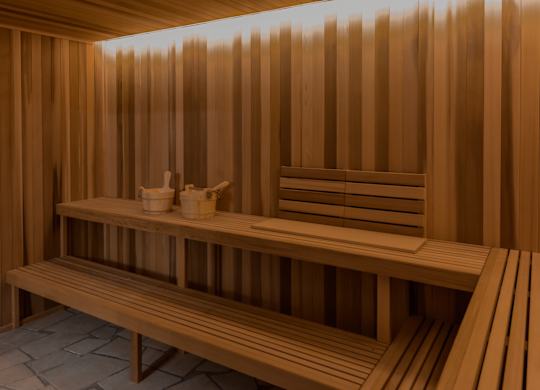 A wooden sauna with benches and towels.