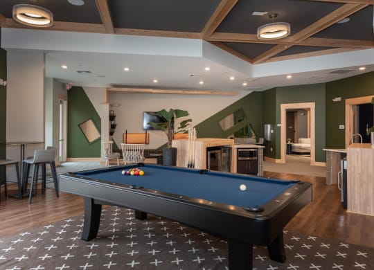 a rec room with a pool table and a flat screen tv