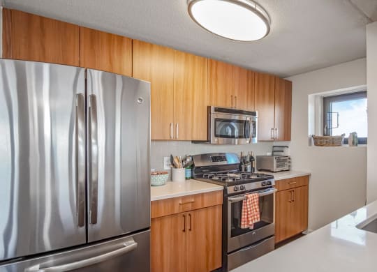 kitchen with brown cabinets, white countertops and stainless steel oven and microwave