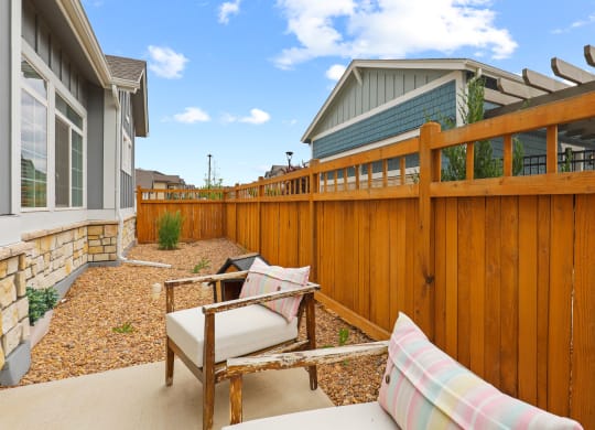 a backyard with a wooden fence and patio furniture
