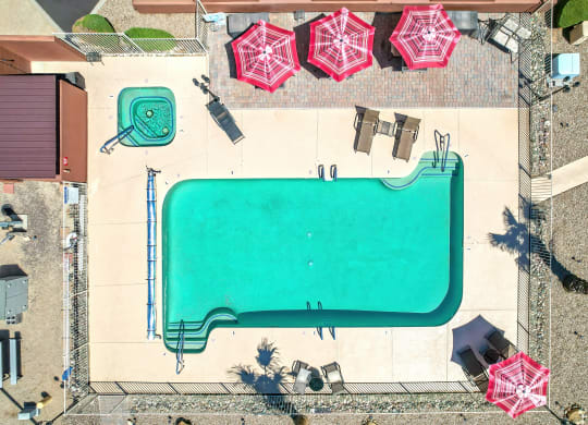 an aerial view of a pool with umbrellas