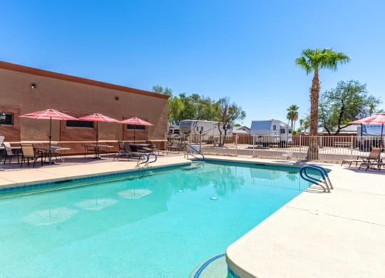 our resort style swimming pool is next to our building with umbrellas