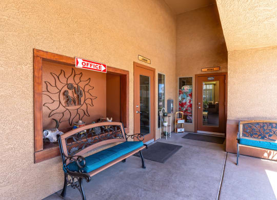 a bench on a porch outside of a building with two doors
