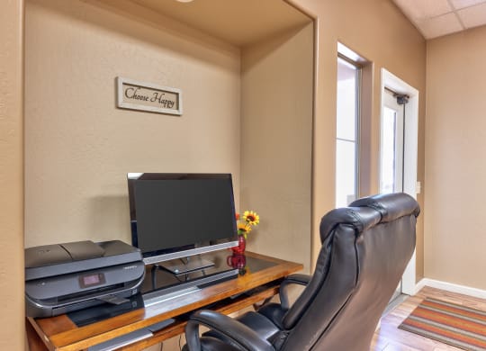 a home office with a desk with a computer and a chair