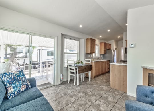 a living room and kitchen with a sliding glass door to a balcony