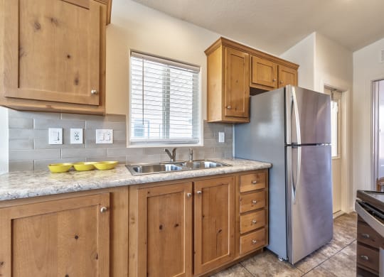 a kitchen with wooden cabinets and a stainless steel refrigerator