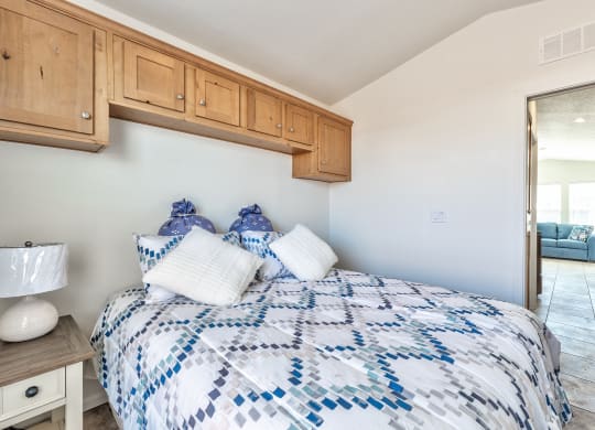 a bedroom with a bed with blue and white comforter