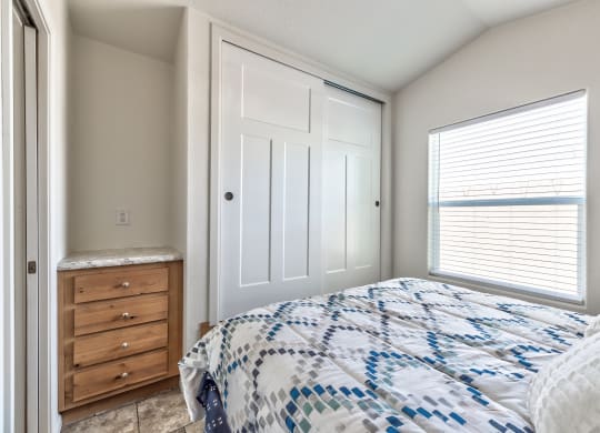 a bedroom with a bed and a dresser and a window