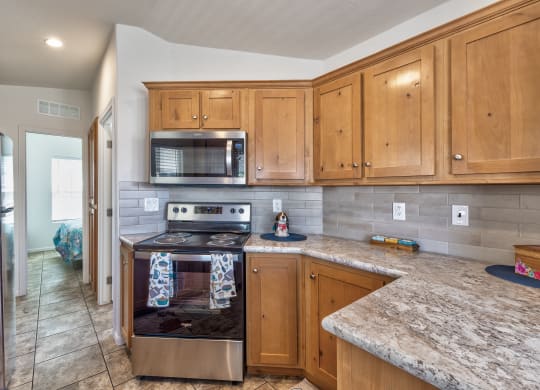 the kitchen has granite counter tops and stainless steel appliances and wood cabinets